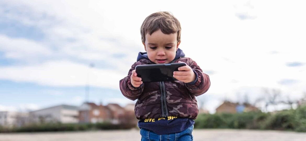 Children surfing the internet outdoors on a iPhone